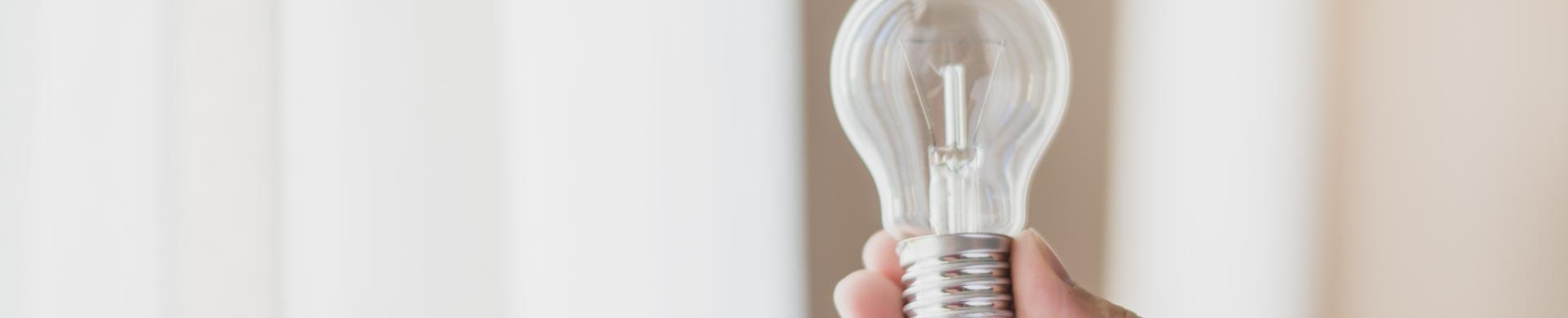 primo-piano-della-mano-dell-uomo-che-tiene-lampadina-trasparente.jpg